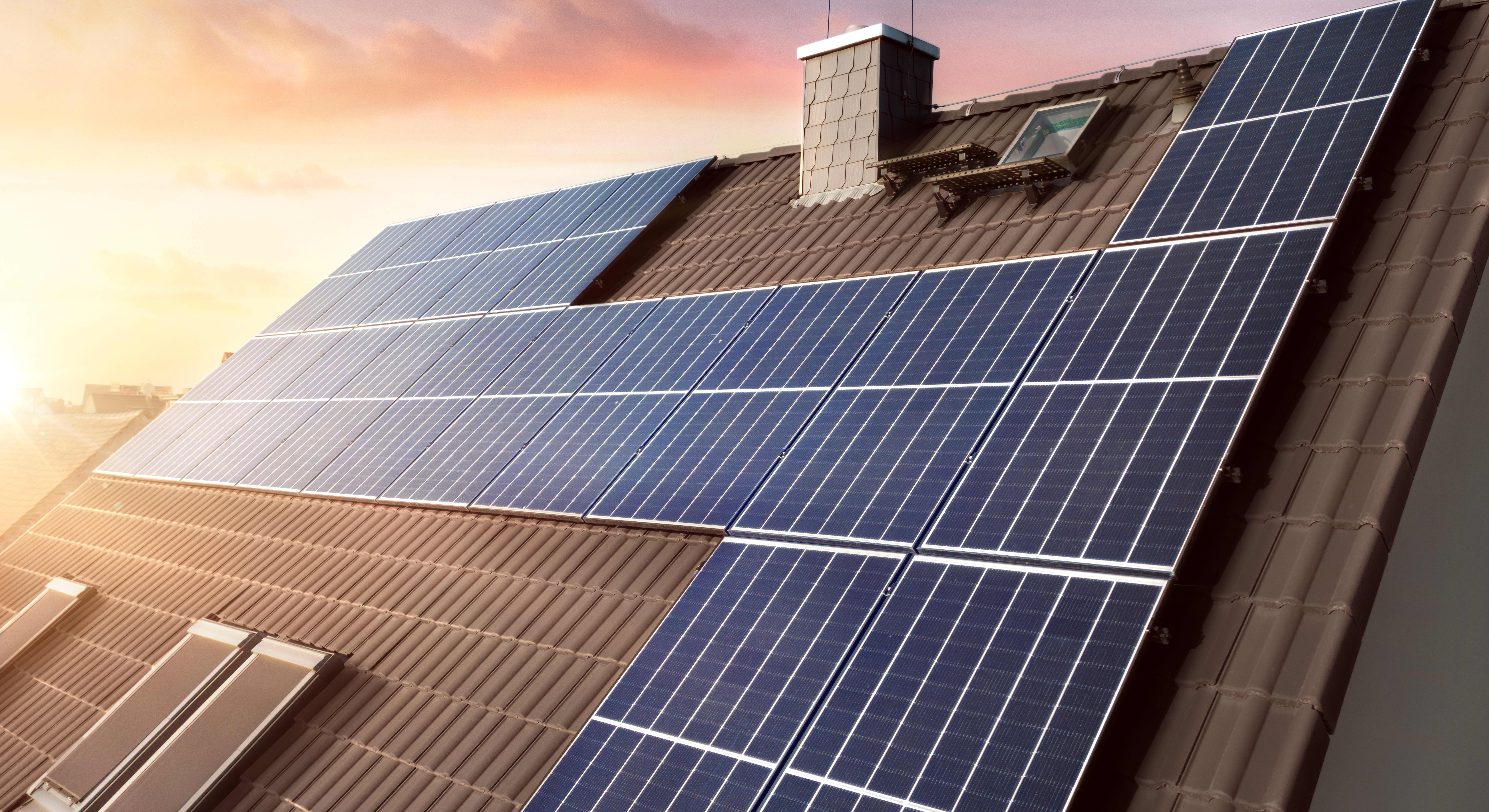 Solaranlage auf einem braunen Hausdach bei Sonnenuntergang