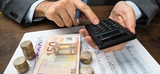Ein Mann im Anzug berechnet die Beträge und zählt das Geld.