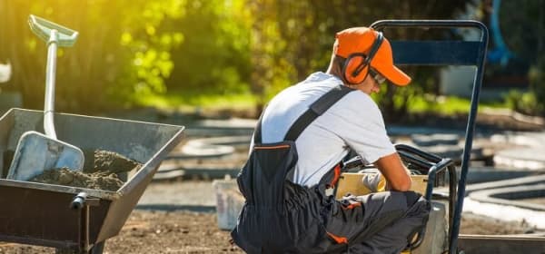 Handwerker bereitet Pflasterung eines Gartenwegs vor.