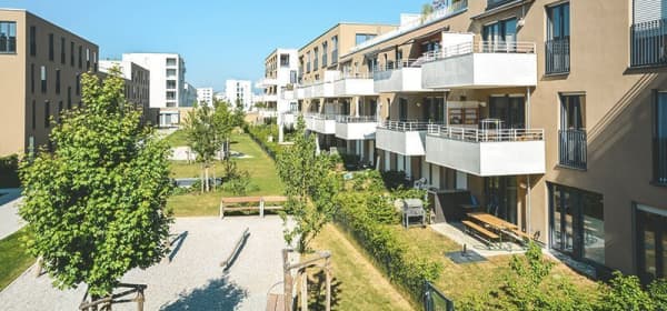 Neubaugegend mit Wohnungen und grünem Innenhof