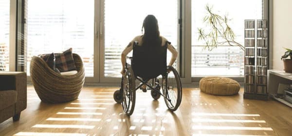 Frau in Rollstuhl im Wohnzimmer