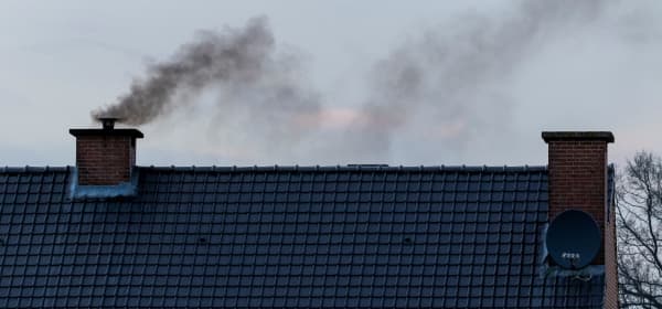 Qualmender Schornstein auf einem Wohnhaus