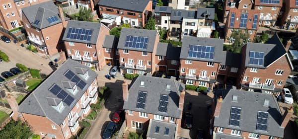 Bild aus der Vogelperspektive auf eine Straße mit vielen Häusern, die eine Solaranlage auf dem Dach installiert haben