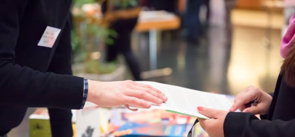 Nahaufnahme zweier Personen an einem Stand auf einer Messe