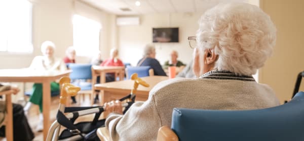 Senioren und Seniorinnen im Aufenthaltsraum eines Pflegeheims