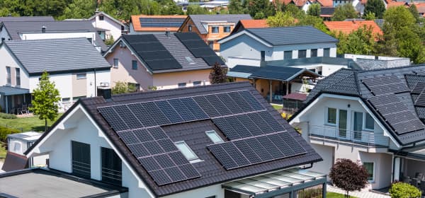 Wohngebiet mit Einfamilienhäusern mit Solaranlagen auf den Dächern im Grünen