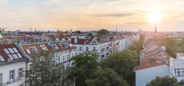 Blick über die Dächer von Mehrfamilienhäusern in einer Stadt bei Sonnenuntergang