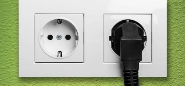 Doppelsteckdose mit schwarzem Stecker in der Wand