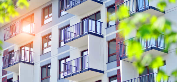 Fassade eines Mehrfamilienhaus-Neubaus mit heller Fassade und Balkons