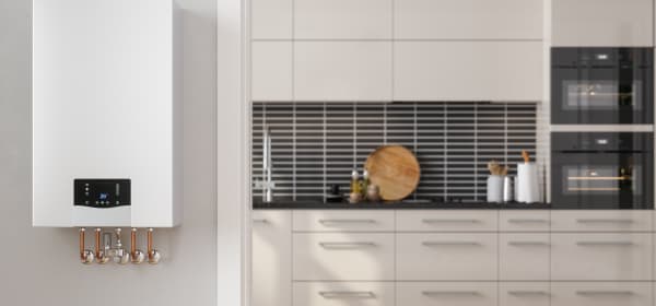 Moderne Gastherme mit weißer Küchenzeile im Hintergrund