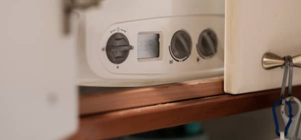 Gas Boiler hinter offener Tür im Haus