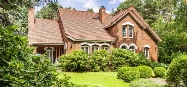 Großes freistehendes Einfamilienhaus mit Ziegelfassade in grünem Garten
