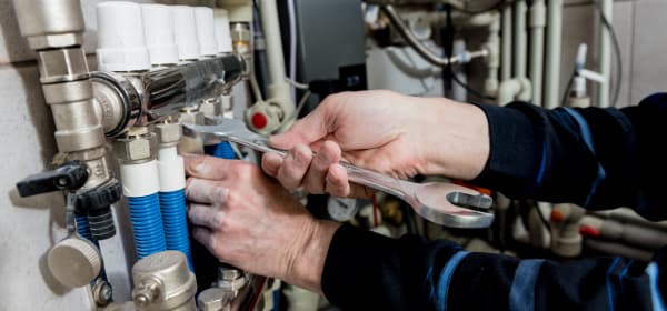 Ansicht der Hände eines Handwerkers, der an einer Heizung arbeitet