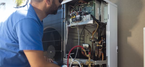 Handwerker arbeitet an der Elektrik einer Wärmepumpe