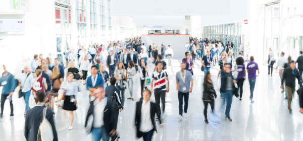 Verschwommene Menschen in einer Veranstaltungshalle auf einer Messe