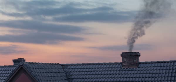 Schornstein mit Rauch und Sonnenuntergang