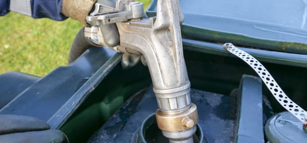 Heizöltank wird von einer Person mit Arbeitshandschuhen betankt