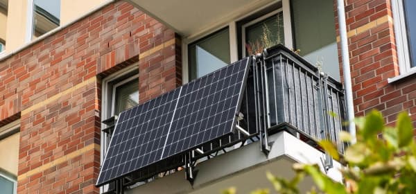 Balkonkraftwerk an einem Wohnhaus mit roter Ziegelfassade