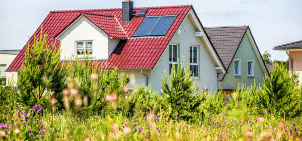 Moderne sanierte Einfamilienhäuser mit grüner Wiese im Vordergrund