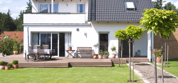 Weißes freistehendes Einfamilienhaus mit Terrasse im Grünen