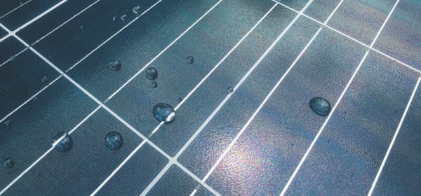 blau schimmernde Solarzellen mit Wassertropfen
