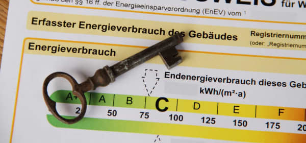 Nahaufnahme eines Energieausweises für Wohngebäude, auf dem ein Schlüssel liegt