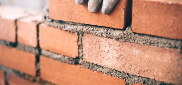 Nahaufnahme der Hand eines Maurers bei der Arbeit