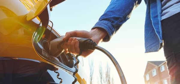 Elektroauto wird auf der Straße vor einem Haus geladen