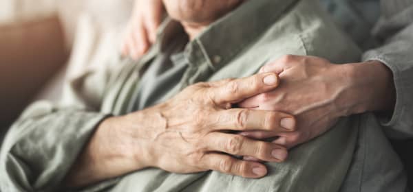 Hände einer Seniorin auf den Schultern eines Seniors