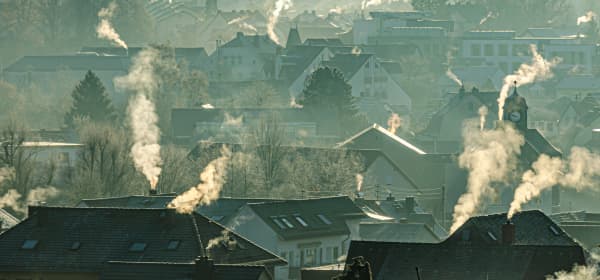 Wohnhäuser in der kalten Jahreszeit mit rauchenden Schornsteinen