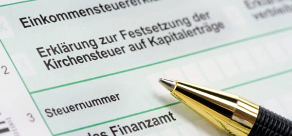 Nahaufnahme einer deutschen Einkommensteuererklärung, auf dem Formular liegt ein Kugelschreiber