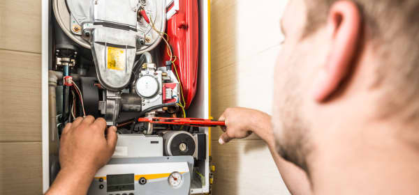 Monteur arbeitet an einer Gastherme