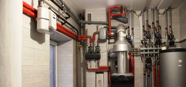 Heizsystem im Heizraum mit Kessel, Wassererhitzer, Ausdehnungsgefäß und Heizungsrohren