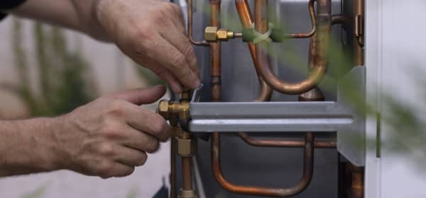 Installateur arbeitet an einer Wärmepumpe