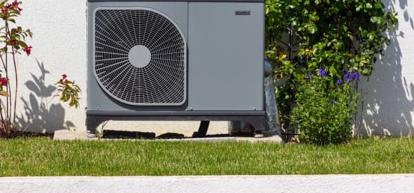 Wärmepumpe im Garten vor einem Eigenheim