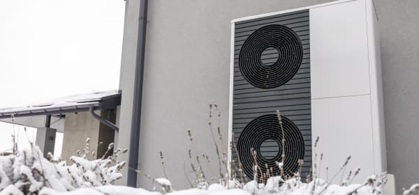 Luft-Wärmepumpen an Fassade eines Wohngebäudes im Schnee