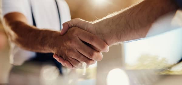 Nahaufnahme zweier Männer, die sich die Hand geben