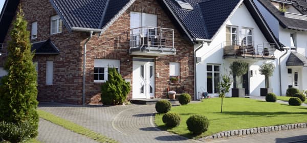 Modernisierte Einfamilienhäuser in Reihe gebaut mit gepflasterter Einfahrt und gepflegtem Rasen