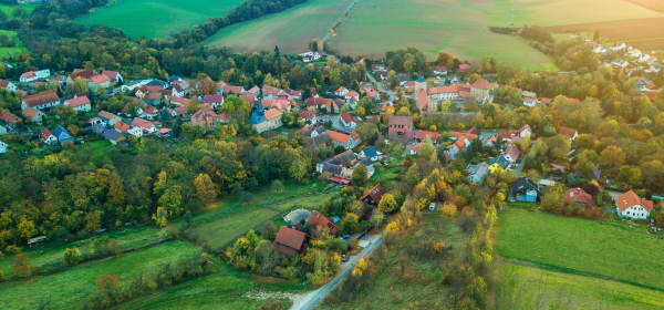 Luftaufnahme einer Ortschaft in Deutschland umgeben von grünen Wiesen