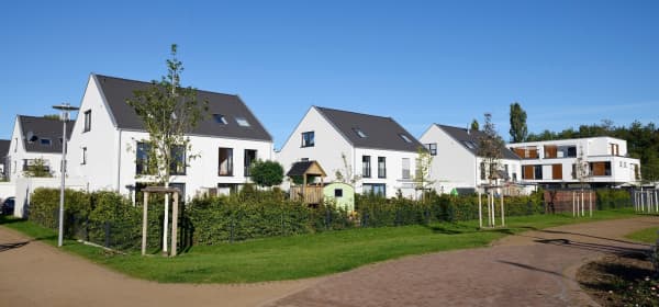 Mehrere moderne, weiße Einfamilienhäuser in ruhiger Wohngegend