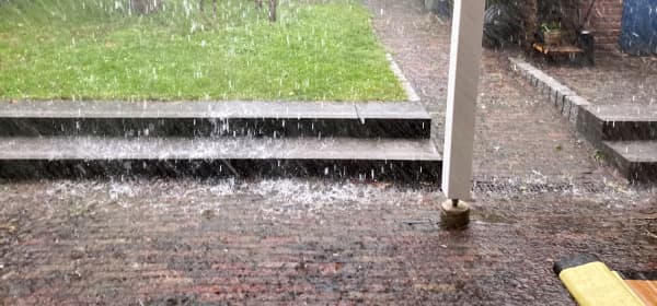 Starker Regen mit viel Wasser auf einer Terrasse
