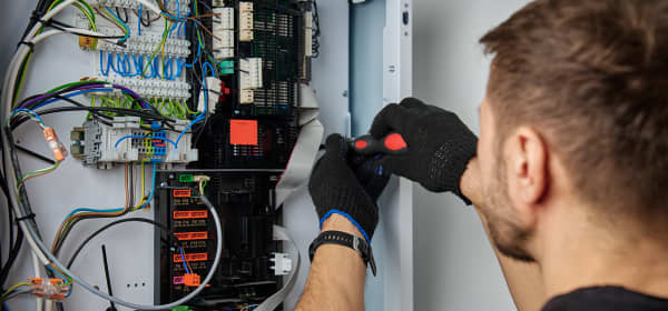 Monteur arbeitet an der Elektronik einer Wärmepumpe