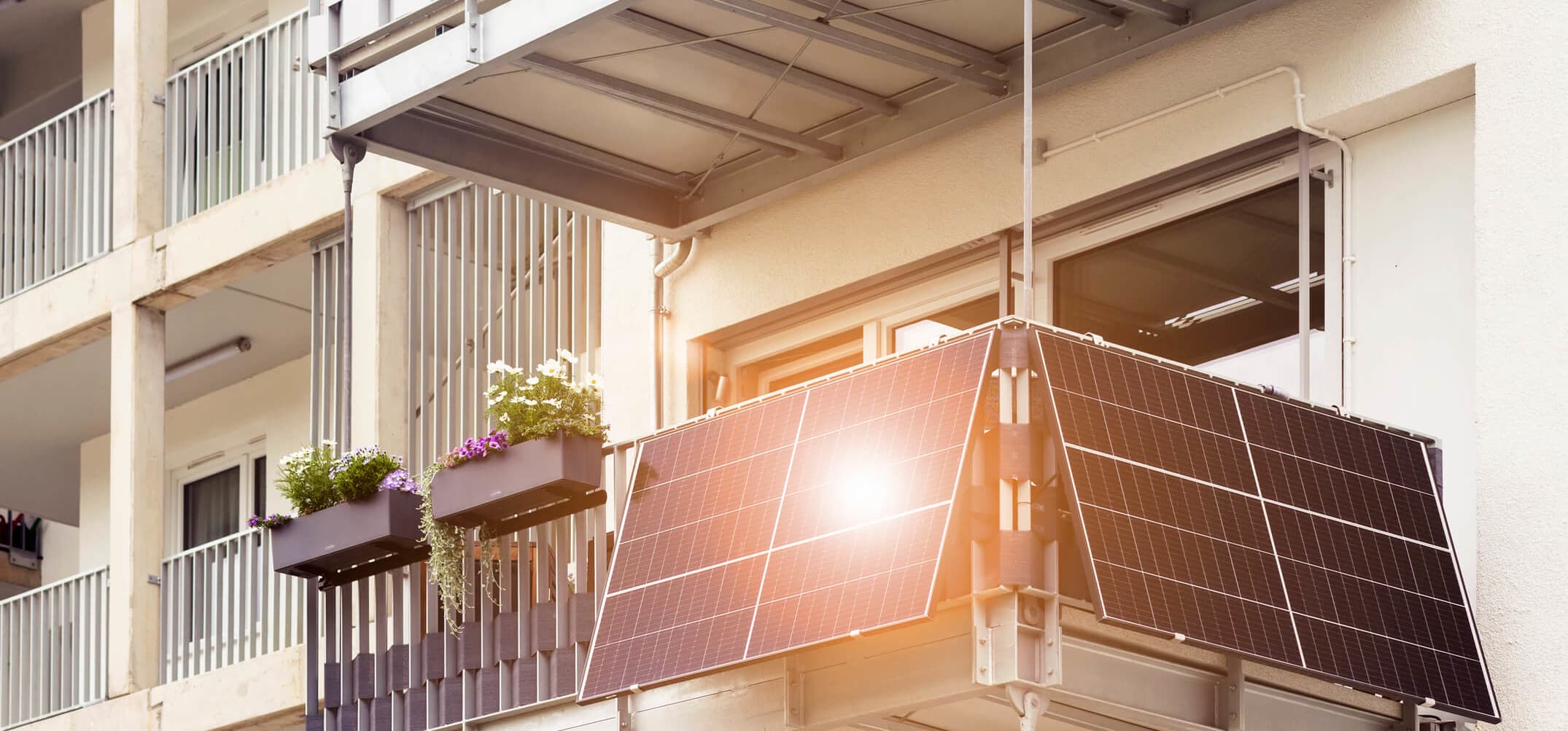 Balkon mit Balkonkraftwerk, dessen Module das Sonnenlicht reflektieren