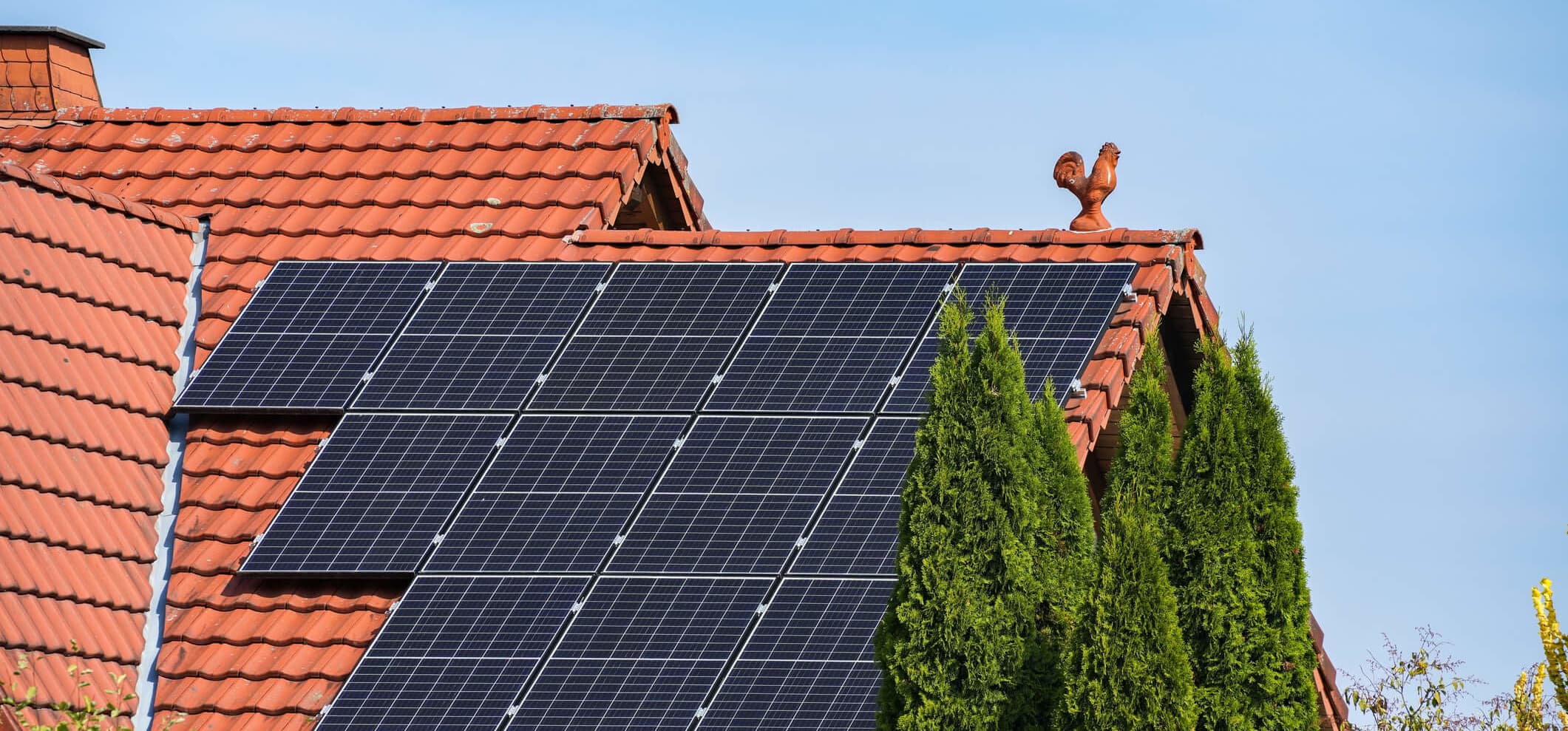 Solarmodule auf rotem Ziegeldach eines Wohnhauses