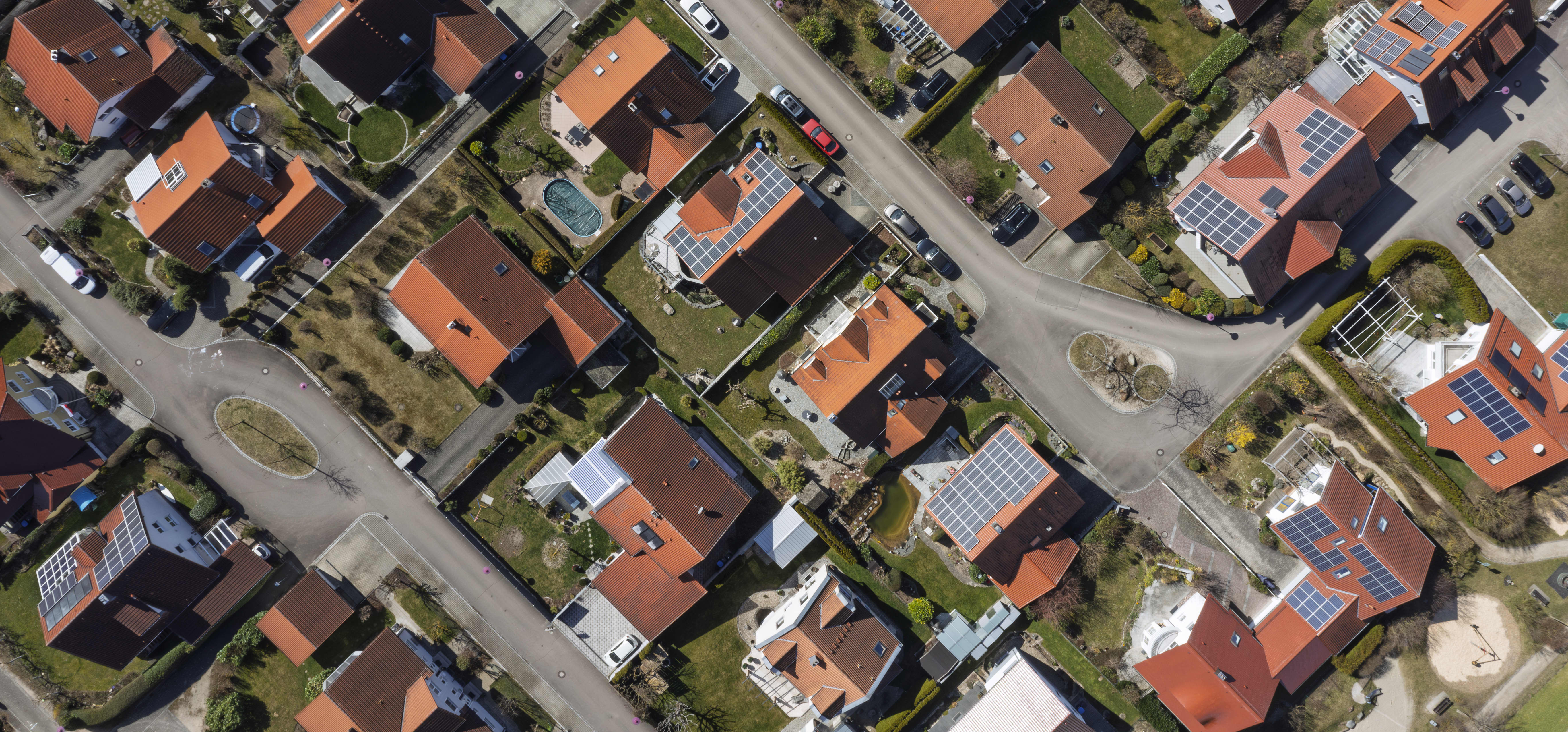 Luftaufnahme eines Wohngebiets mit Häusern, von denen einige mit Solaranlagen ausgestattet sind