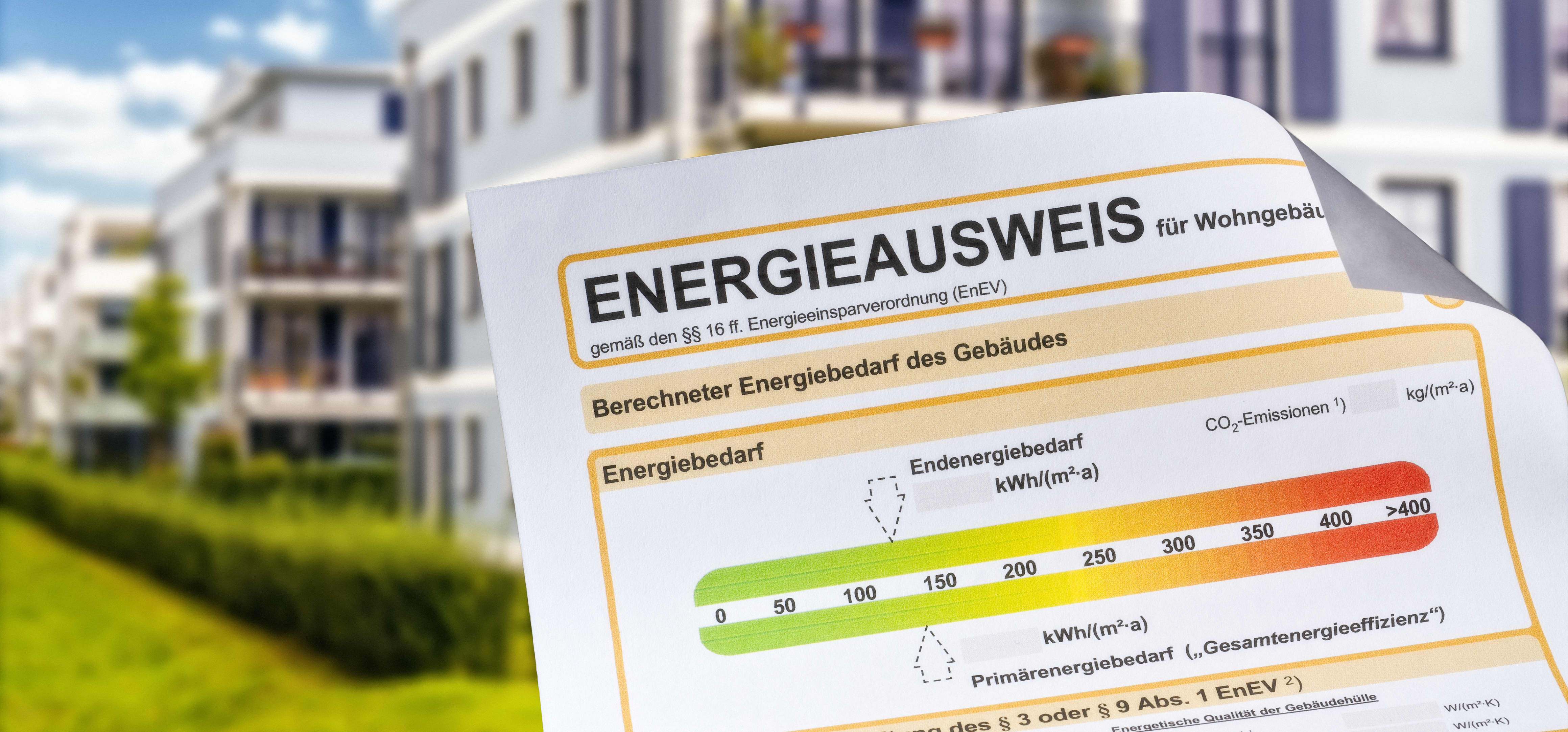 Energieausweis mit modernem Mehrfamilienhaus im Hintergrund