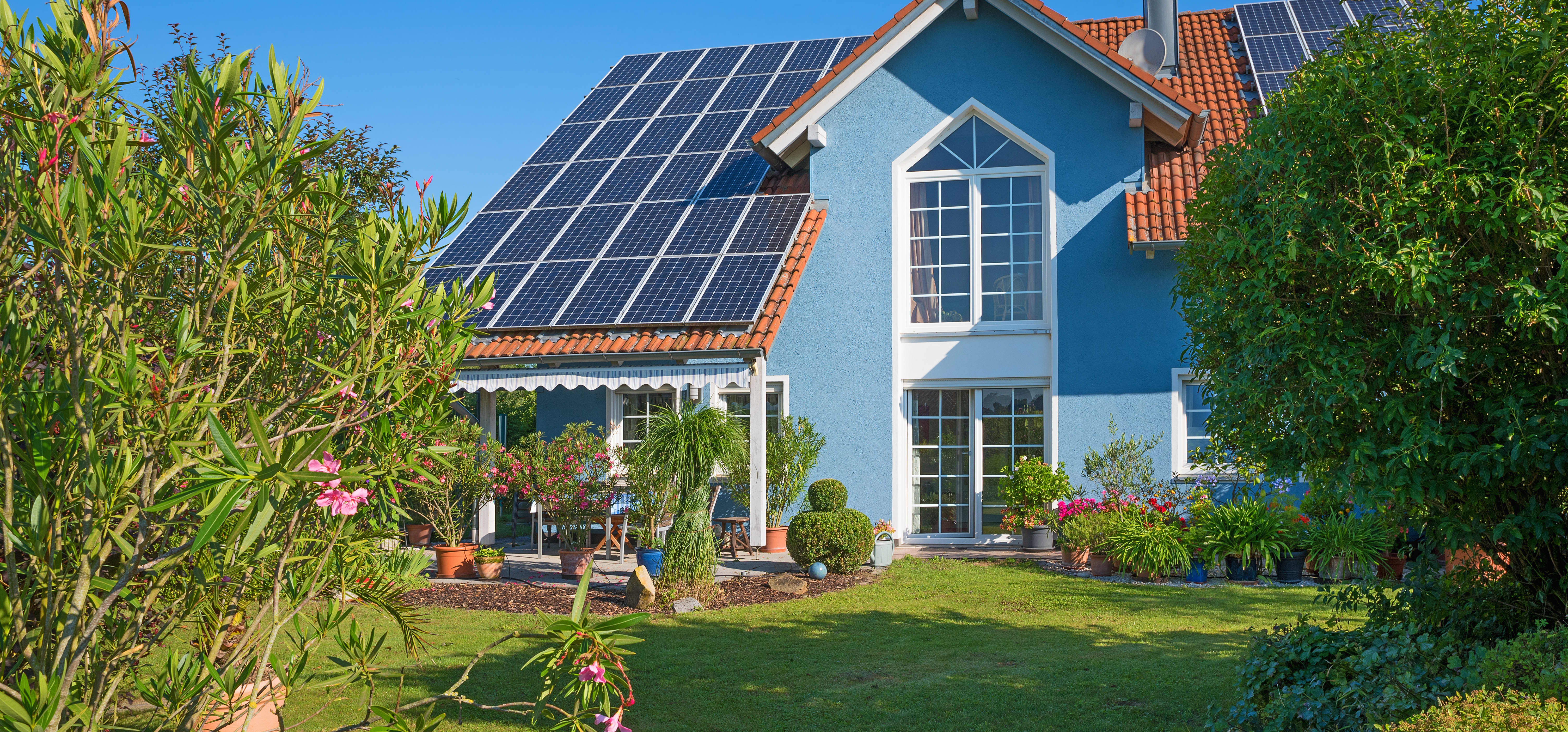 Einfamilienhaus mit Solaranlage auf dem Dach und gepflegtem Garten