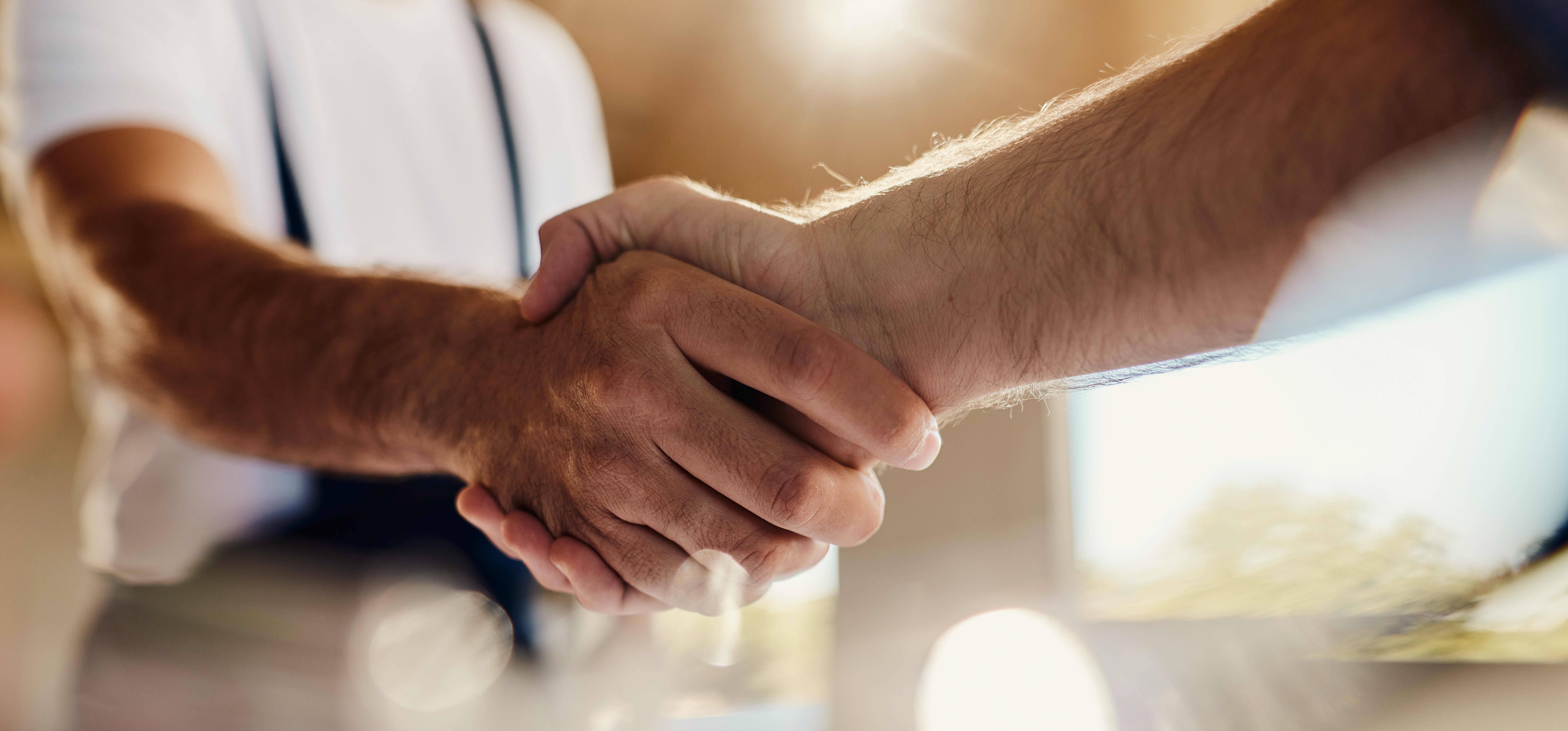 Nahaufnahme zweier Männer, die sich die Hand geben