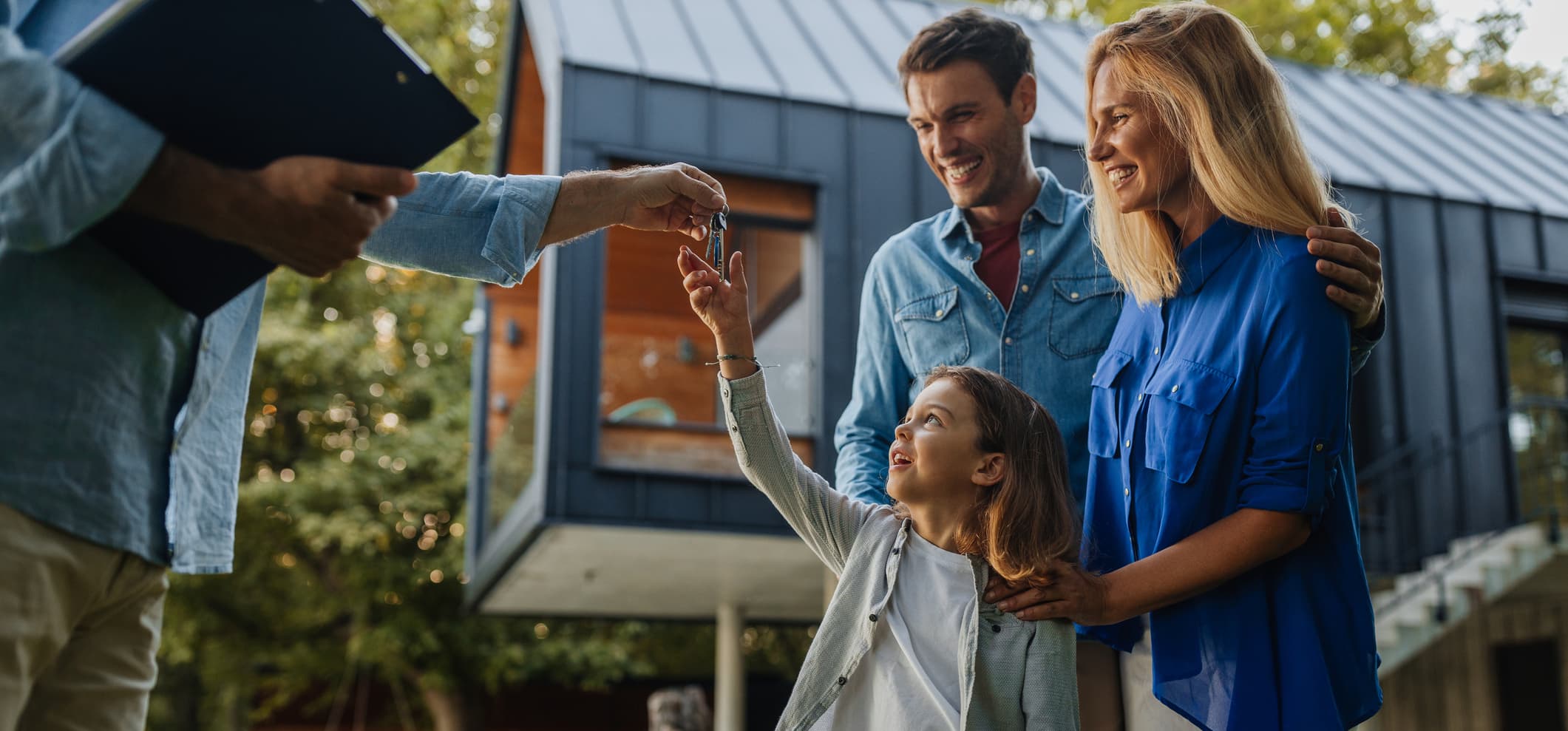 Kind und seine Eltern erhalten Schlüssel für ihr neues Haus von Immobilienmakler