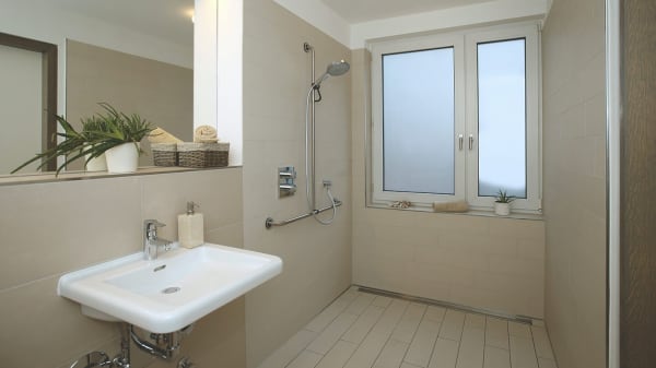 Barrierefreies Bad mit beigen Fließen